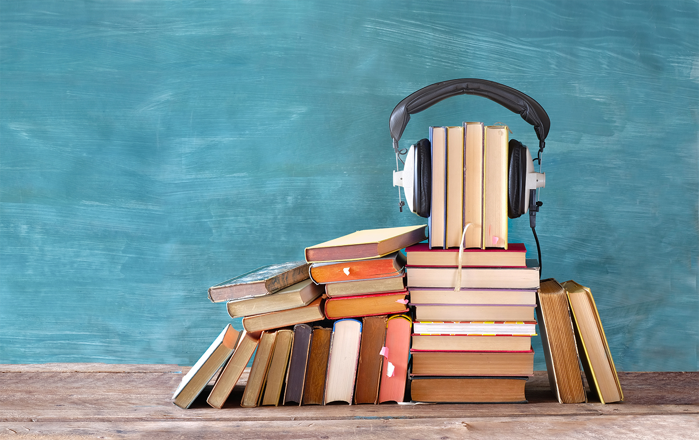 auditory processing and reading represented by a stack of books with headphones